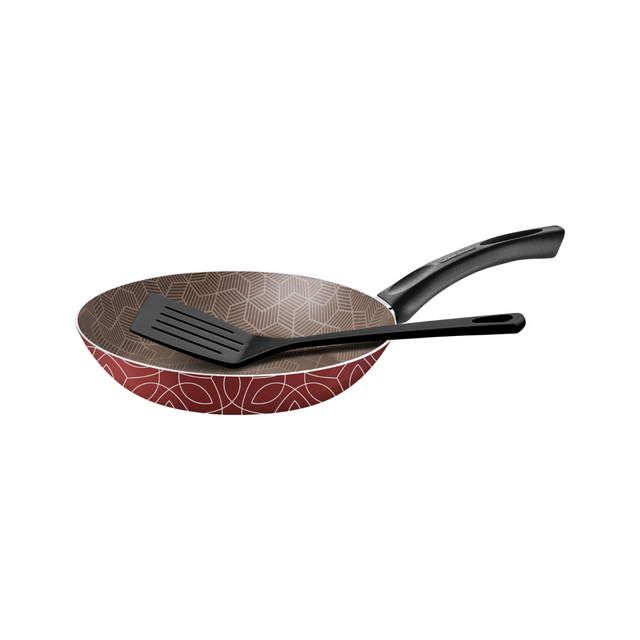 Nonstick frying pan with red geometric pattern and black spatula accessory set.