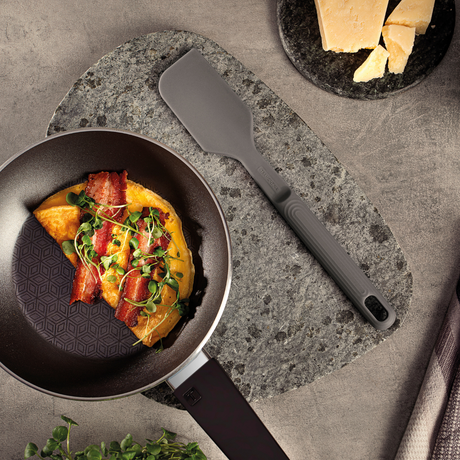 Grey silicone spatula with wide head and textured grip handle