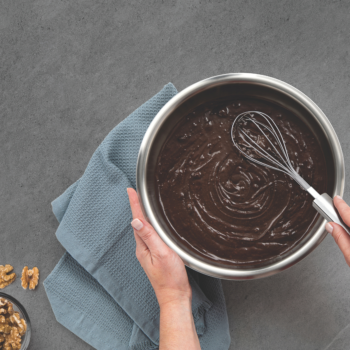 Silver stainless whisk with wire loops mixing chocolate in a saucepan