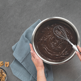 Silver stainless whisk with wire loops mixing chocolate in a saucepan