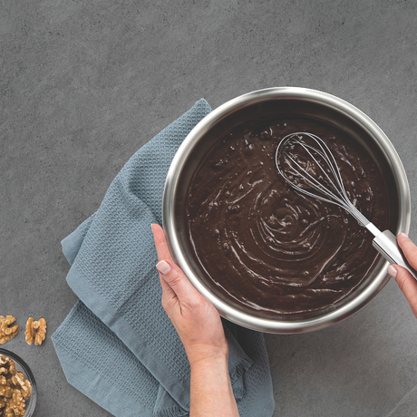 Silver stainless whisk with wire loops mixing chocolate in a saucepan