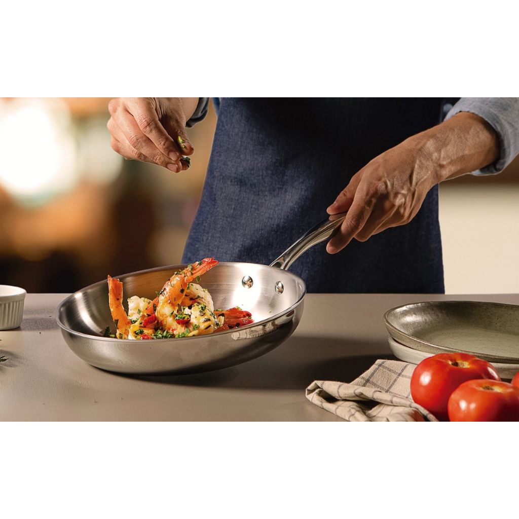 Stainless steel skillet with riveted handles holding mixed vegetables