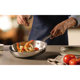 Stainless steel skillet with riveted handles holding mixed vegetables